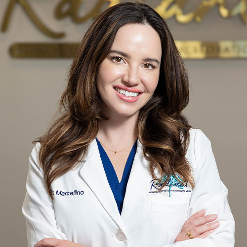 Smiling Dr. Marcellino in a white lab coat with folded arms.